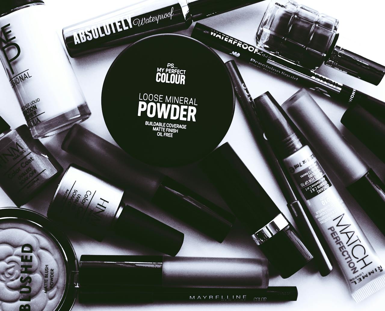 Home Elegant monochrome flatlay showcasing a collection of beauty products and cosmetics.
